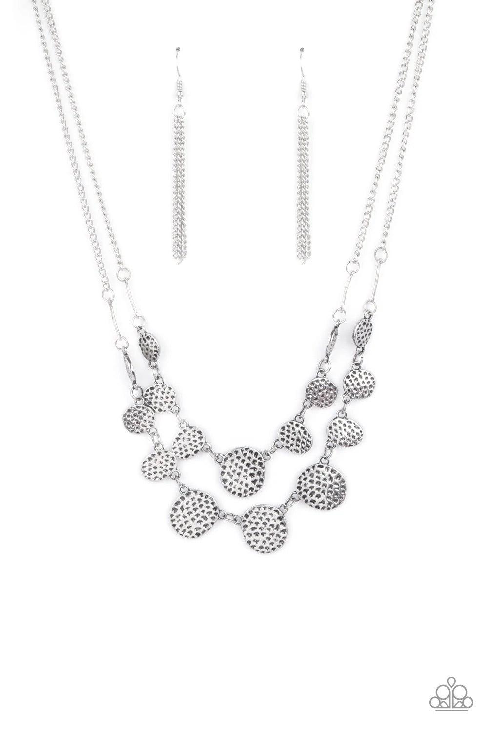 Paparazzi Accessories Pebble Me Pretty - Silver A double row of delicately hammered and dotted silver discs gently lay across the collar. Gradually increasing in size, they connect to silver chains for a simple statement. Features an adjustable clasp clos