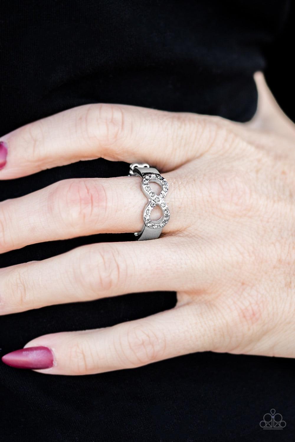 Paparazzi Accessories Once Upon A TIMELESS - Silver Encrusted in smoky rhinestones, a silver infinity loops across the finger in a timeless fashion. Features a dainty stretchy band for a flexible fit. Jewelry