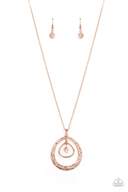 Paparazzi Accessories Tasteful Teardrops - Copper An iridescent peach crystal-like bead twinkles from the top of two mismatched shiny copper teardrop frames at the bottom of an extended shiny copper chain, resulting in a tasteful and timeless pendant. Fea