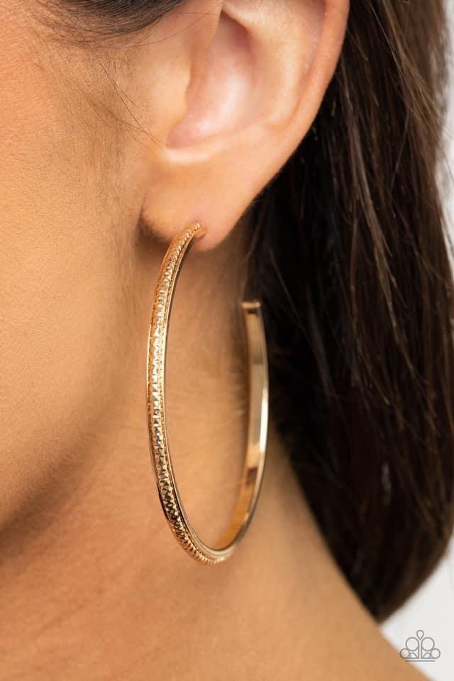 Paparazzi Accessories Sultry Shimmer - Gold Featuring shimmery diamond-cut texture, a glistening gold bar lines the center of a beveled gold hoop, creating an edgy stacked look. Earring attaches to a standard post fitting. Hoop measures approximately 2 1/