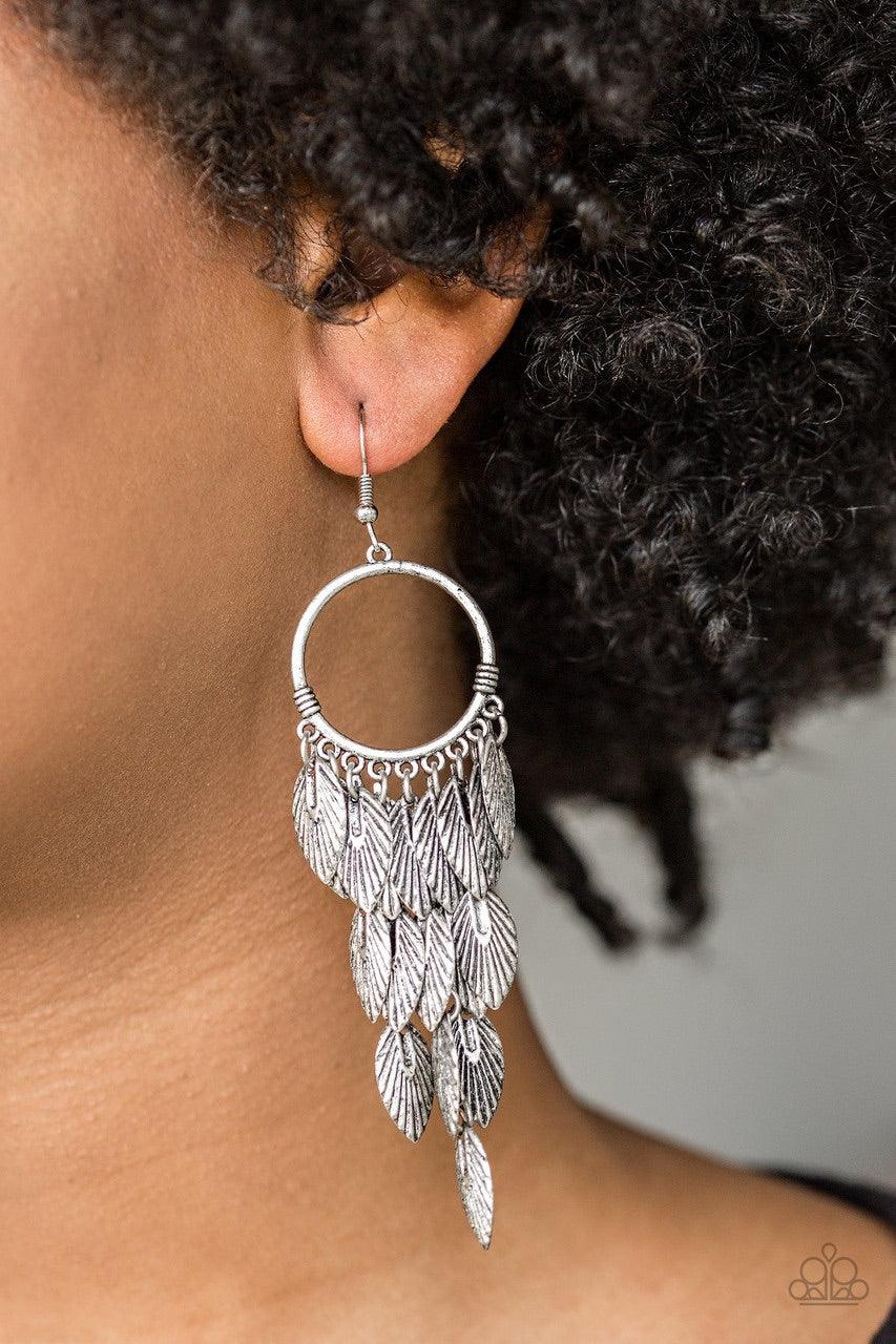 Paparazzi Accessories Feather Frenzy - Silver Brushed in an antiqued shimmer, lifelike silver feathers stream from the bottom of a glistening silver hoop, coalescing into a whimsical fringe. Earring attaches to a standard fishhook fitting. Jewelry