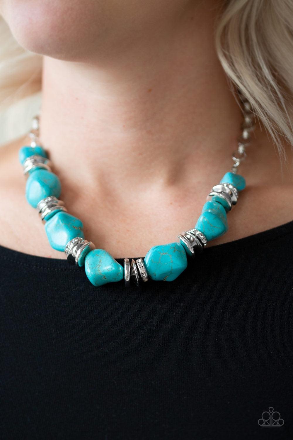 Paparazzi Accessories Stunningly Stone Age - Blue A collection of refreshing turquoise stones, shimmery silver accents, and white rhinestone encrusted rings are strung below the collar for a timeless look. Features an adjustable clasp closure. Jewelry